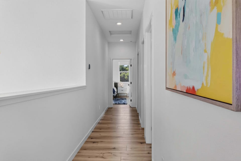 Drift down the hallway past abstract art, where each doorway opens to another quiet corner of the house.