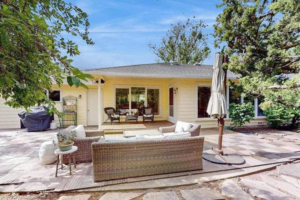 Your spacious backyard oasis connects seamlessly to the indoors through wide sliding doors — lounge on plush cushions or step inside to stoke the fireplace as evening falls.