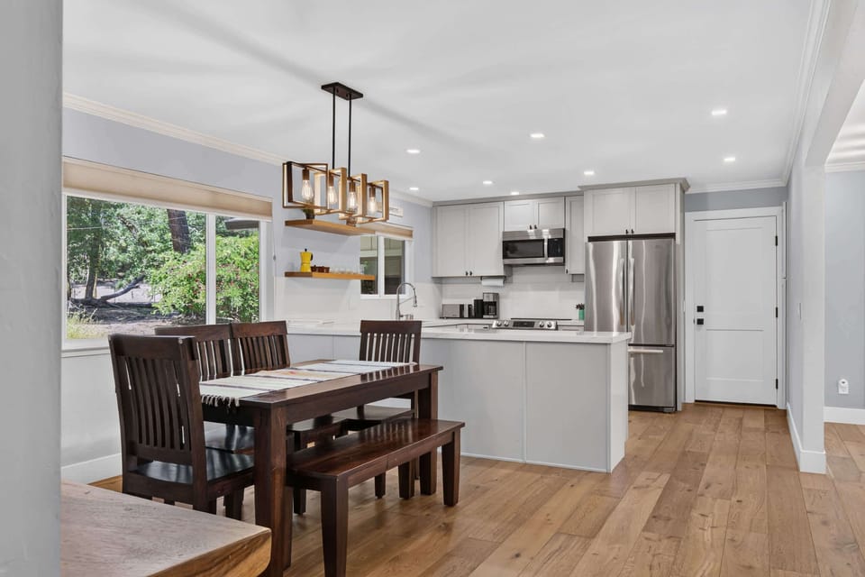 Gather six around the dark wood farm table while the chef works the quartz island, lit by an Edison-bulb chandelier.