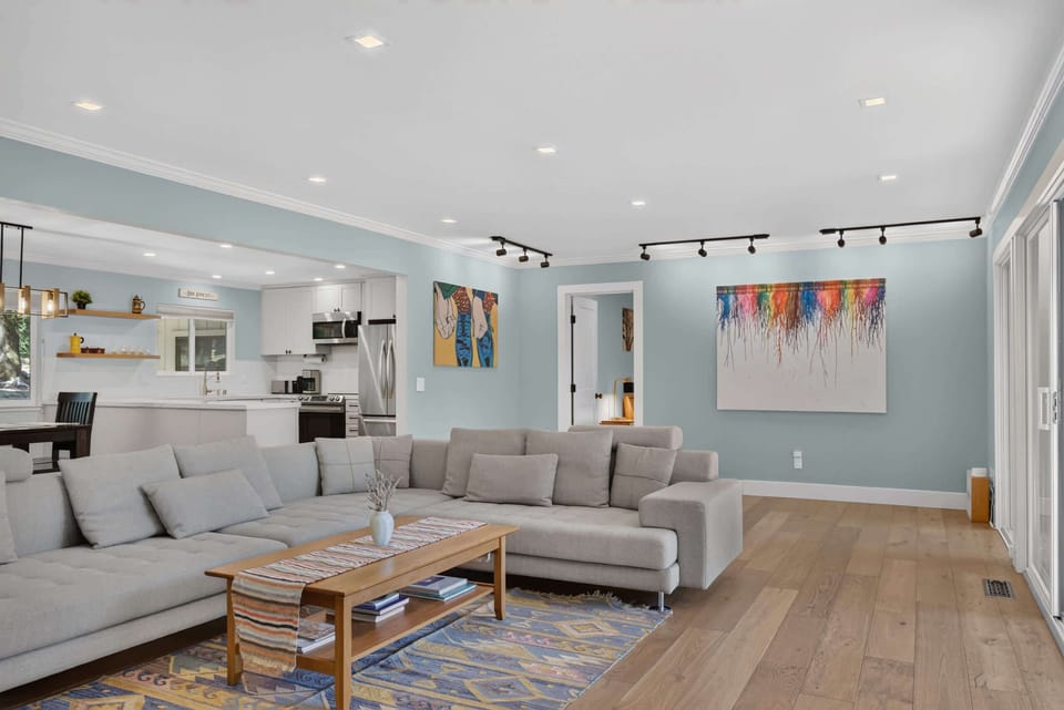 Kick back on the deep gray sectional with the open kitchen at your back and pops of color art guiding your eye across the great room.