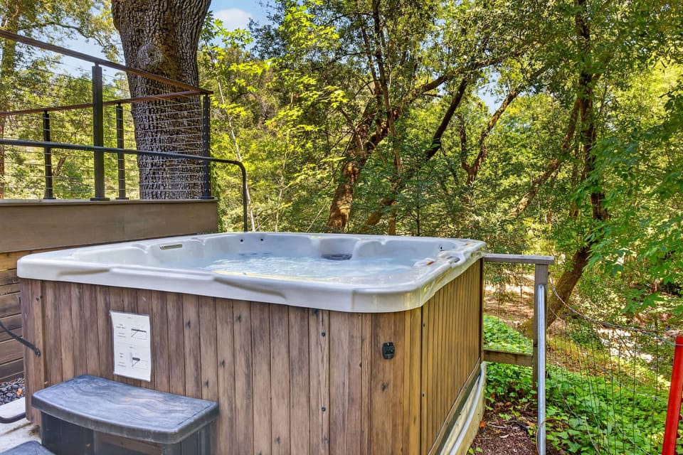 Tucked below the deck under the oak canopy, the private hot tub bubbles away in total forest seclusion.