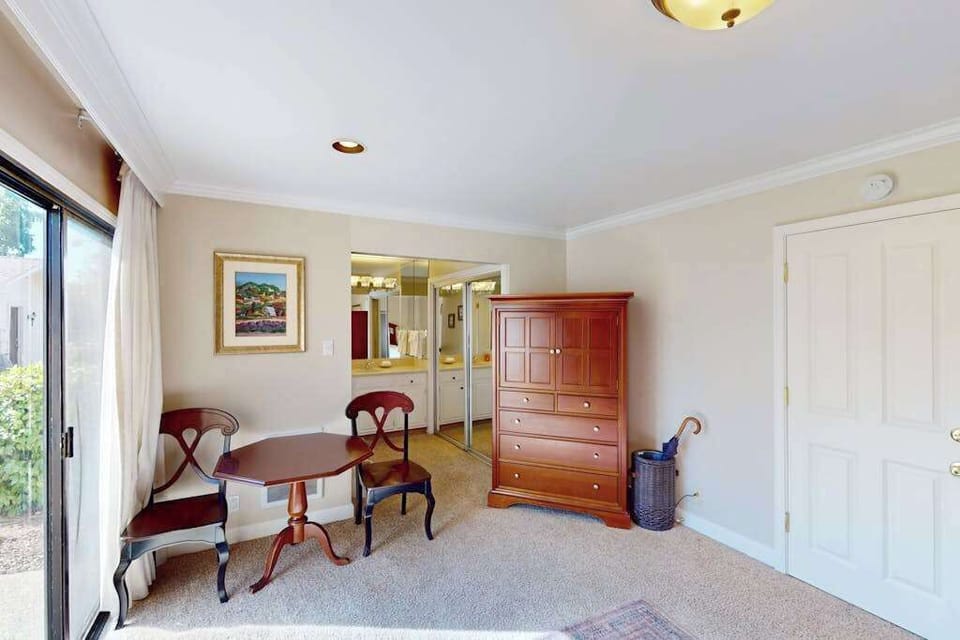 Plan your Napa tasting itinerary at the in-room bistro table — the cherry wood armoire and mirrored entry lend a polished resort feel to your private suite.