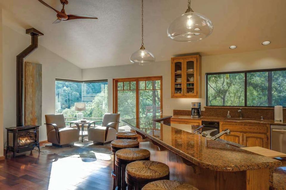 Morning light floods through picture windows as you brew coffee at the granite island — sunlit breakfast nook and cozy gas stove steps away.