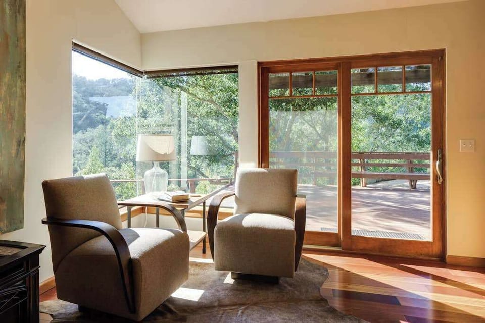 Pull up a chair in this sun-washed reading nook — floor-to-ceiling glass opens to the deck and the scent of warm oak and lavender.