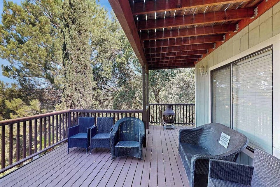 Unwind on your covered deck with wicker lounge seating and dappled sunlight through the pergola — a private perch above the Cloverdale treetops.