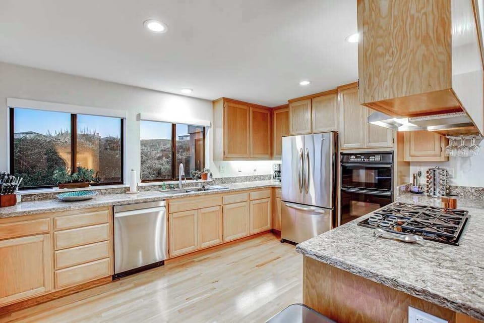 Your fully equipped chef's kitchen features a gas range, double wall oven, stainless fridge, dishwasher, and granite countertops throughout