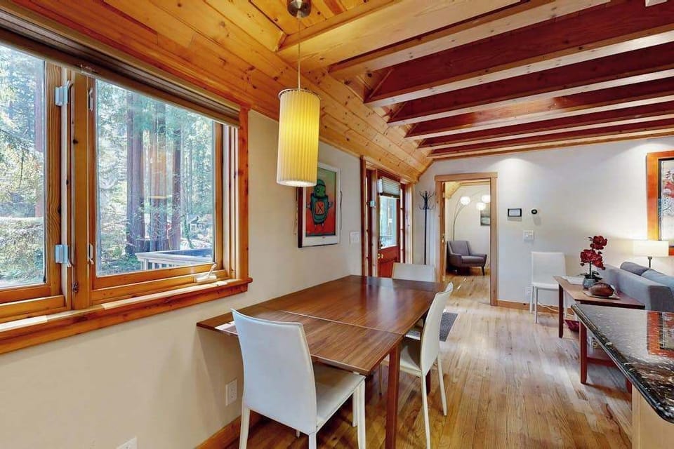 Share farm-to-table meals at your sunlit dining table framed by floor-to-ceiling redwood views — a pendant lamp sets the mood for your Monte Rio evenings.