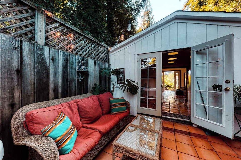 As twilight settles over Guerneville, your cottage glows warmly through open French doors — step between indoor comfort and your private patio retreat.
