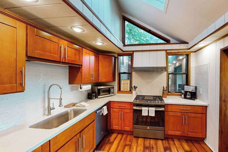 Gas range, microwave, and generous counter space beneath clerestory windows — your kitchen is made for Sonoma-inspired meals with redwood treetop views while you cook.