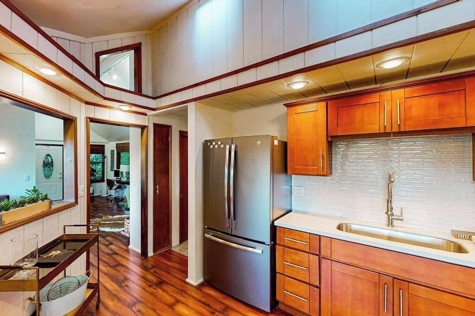 Your fully equipped kitchen features stainless steel appliances, warm cherry cabinets, and gleaming countertops — everything you need to cook with your farmers market finds.