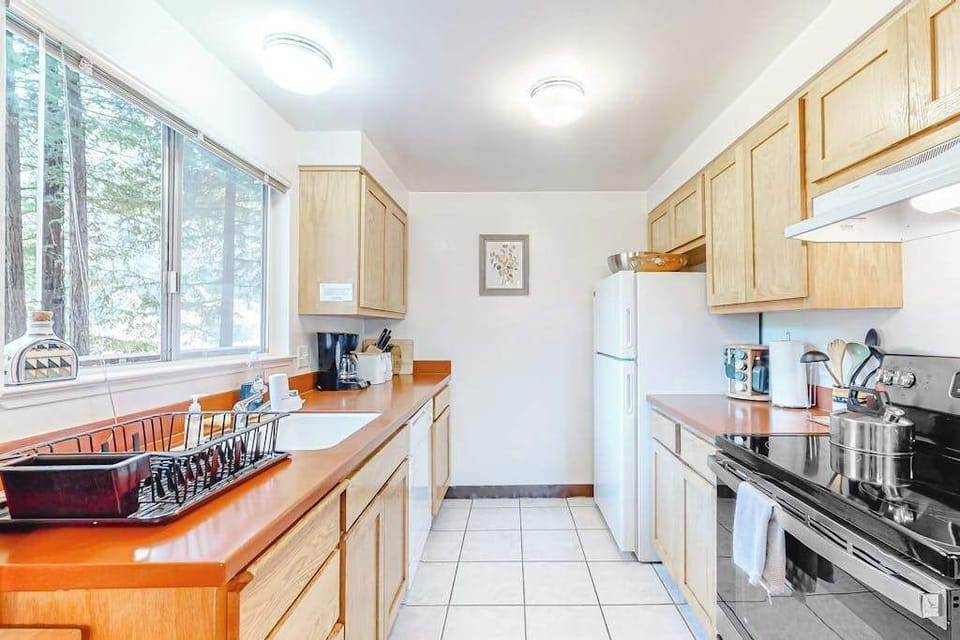 Whip up vineyard-inspired meals in your fully equipped kitchen — ample counter space, modern appliances, and redwood canopy views from the window.