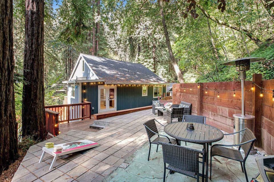 Step outside your charming canyon cottage onto a spacious deck surrounded by old-growth redwoods — string lights set the mood for alfresco dining under the canopy.