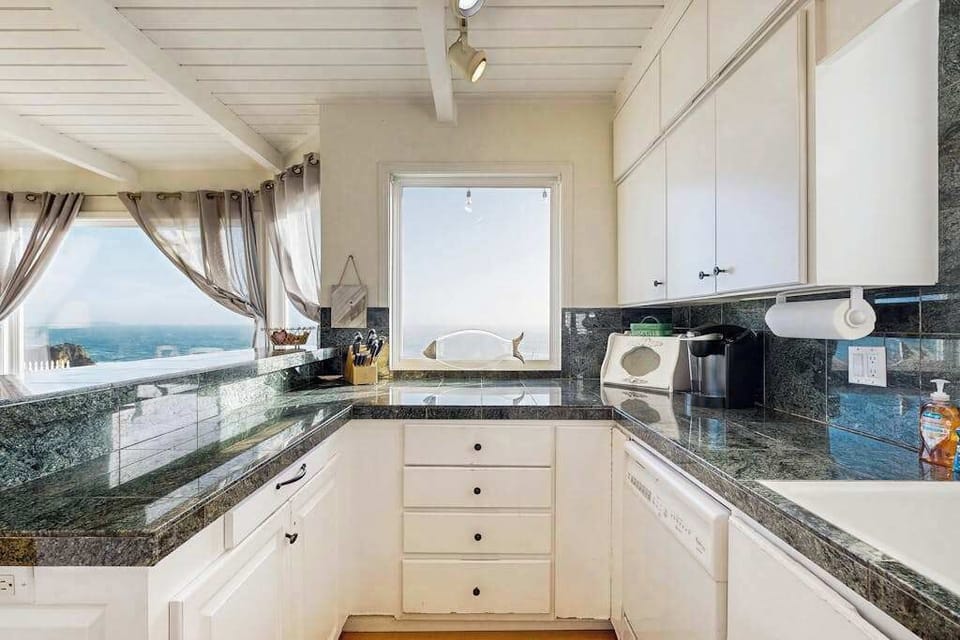 Prepare your morning coffee while watching waves roll in through the kitchen window at this seaside retreat