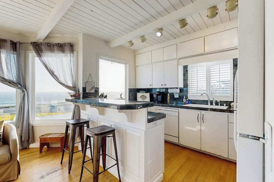 Cook with a view — your fully equipped kitchen features granite counters, breakfast bar, and Pacific Ocean vistas