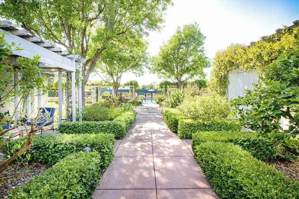 Wander through Silverado's lush garden pergola where manicured hedges and dappled light set the scene for your Napa stroll
