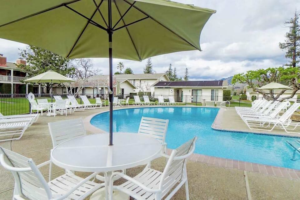 Relax poolside with mountain views under a shaded umbrella — your Napa Valley getaway includes this stunning resort setting