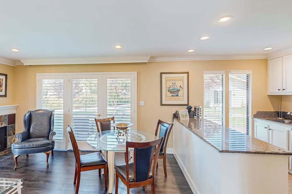 Enjoy meals at the glass dining table with views through French doors — your open-concept kitchen and bar counter keep the conversation flowing.