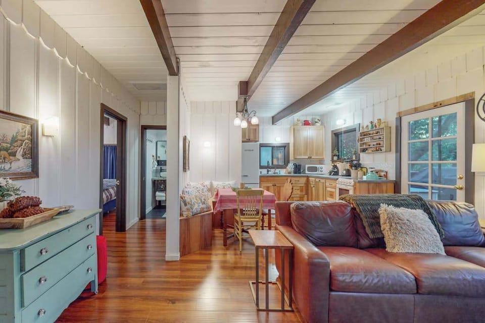 Exposed beams and warm hardwood floors create that quintessential Sonoma County cabin charm — the open layout flows from cozy living room to kitchen in one inviting space.