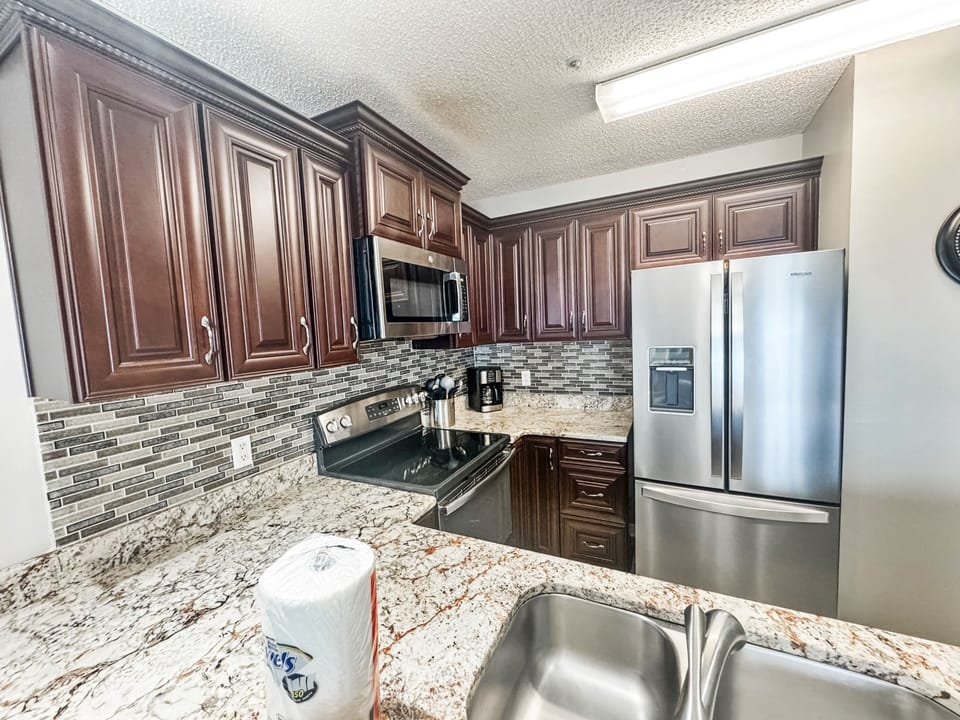 This kitchen has stainless steel appliances, a coffee maker, toaster and more.