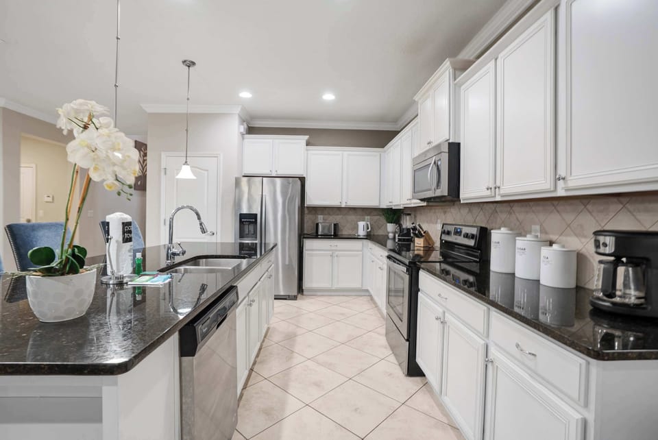 Modern kitchen with white cabinetry and stainless steel appliances
