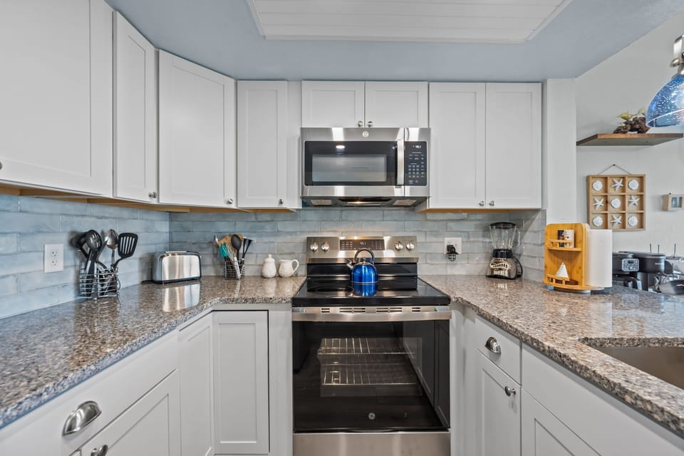 Fully stocked kitchen with modern appliances, granite counters, and everything you need for easy meals in
