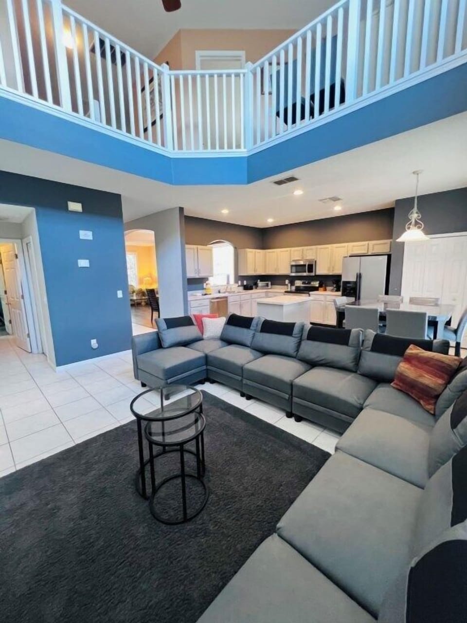 Spacious living area with plush sectional sofa and open kitchen, perfect for entertaining.