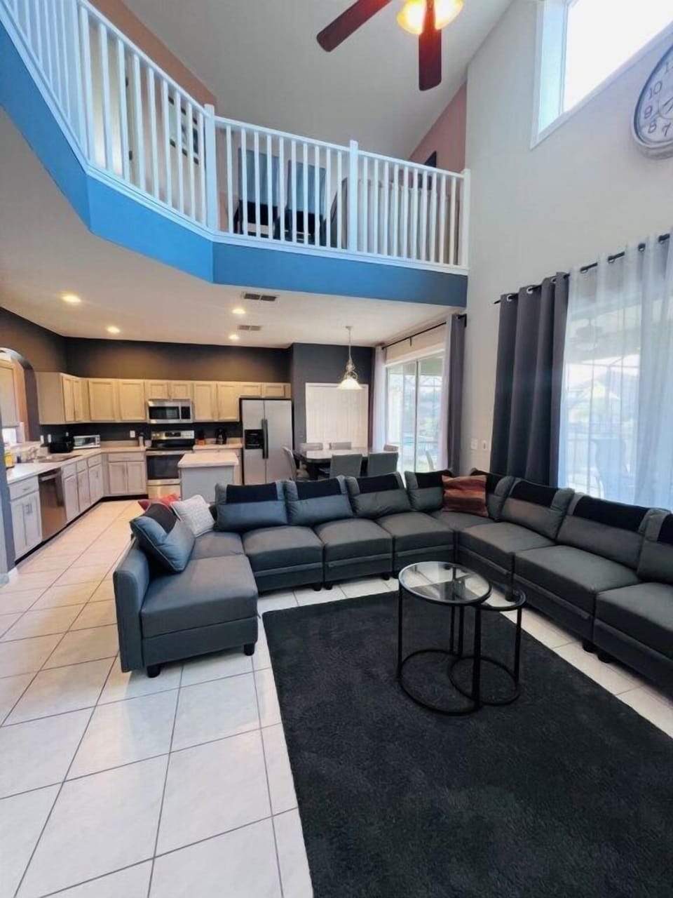 Spacious open-plan living area with cozy sectional and modern kitchen, perfect for gatherings.