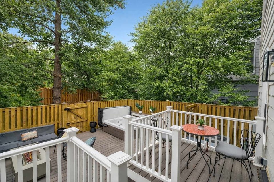 Thoughtfully designed fenced backyard retreat offering deck dining, gas concrete fire table seating, and a hot tub with fountain and LED ambiance.