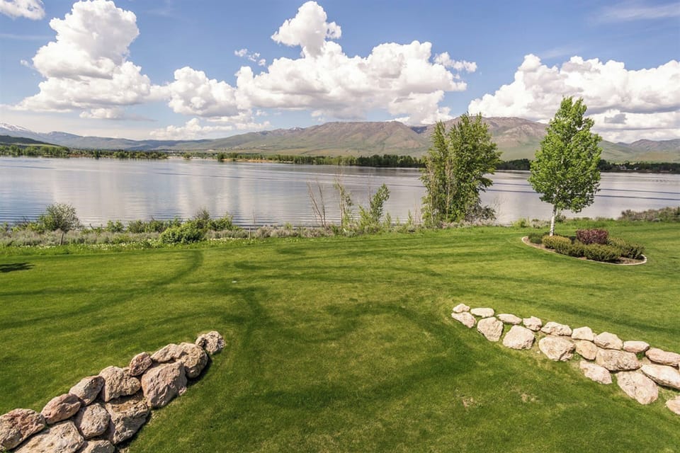 Expansive green space leading to the lake offers a peaceful, open setting perfect for picnics, play, or simply soaking in the mountain scenery.