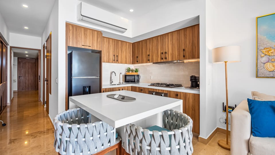 Fully equipped kitchen with clean lines, white countertops, and warm wood cabinetry, perfect for cooking, entertaining, or casual meals.