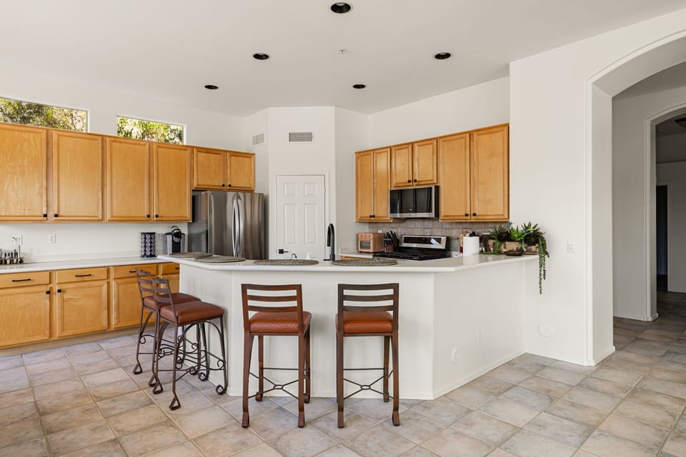 Cook and gather in this spacious, fully equipped kitchen featuring ample counter space, bar seating, and an open layout perfect for entertaining.