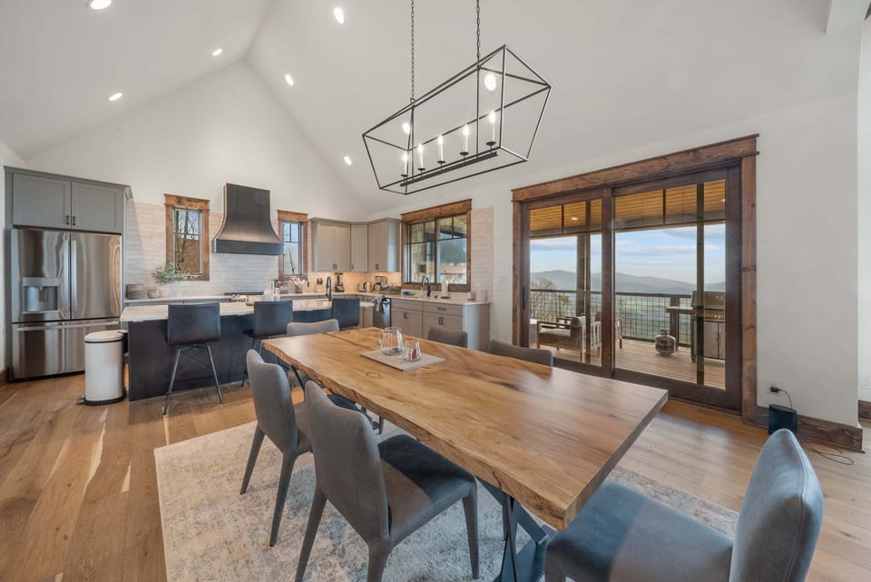 Gather around the stunning live-edge table with Blue Ridge mountain views just beyond the glass. Soaring ceilings and an open kitchen make every meal feel special.