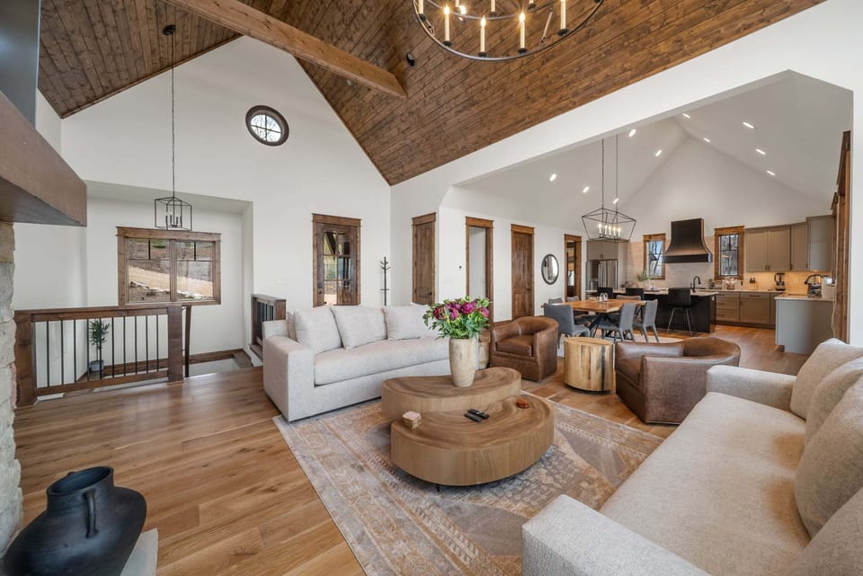 Soaring vaulted ceilings and warm wood tones set the tone in this open great room, flowing seamlessly into the dining area and kitchen.