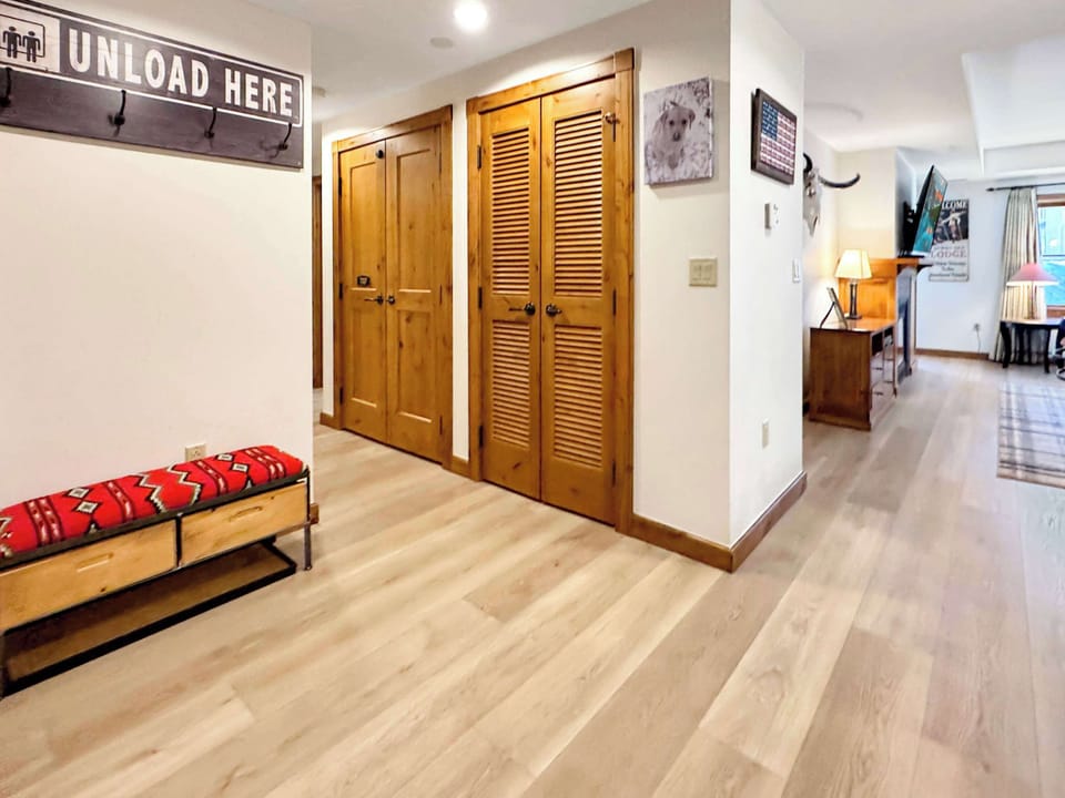 entry hall with light wood-plank flooring and paneled wooden doors