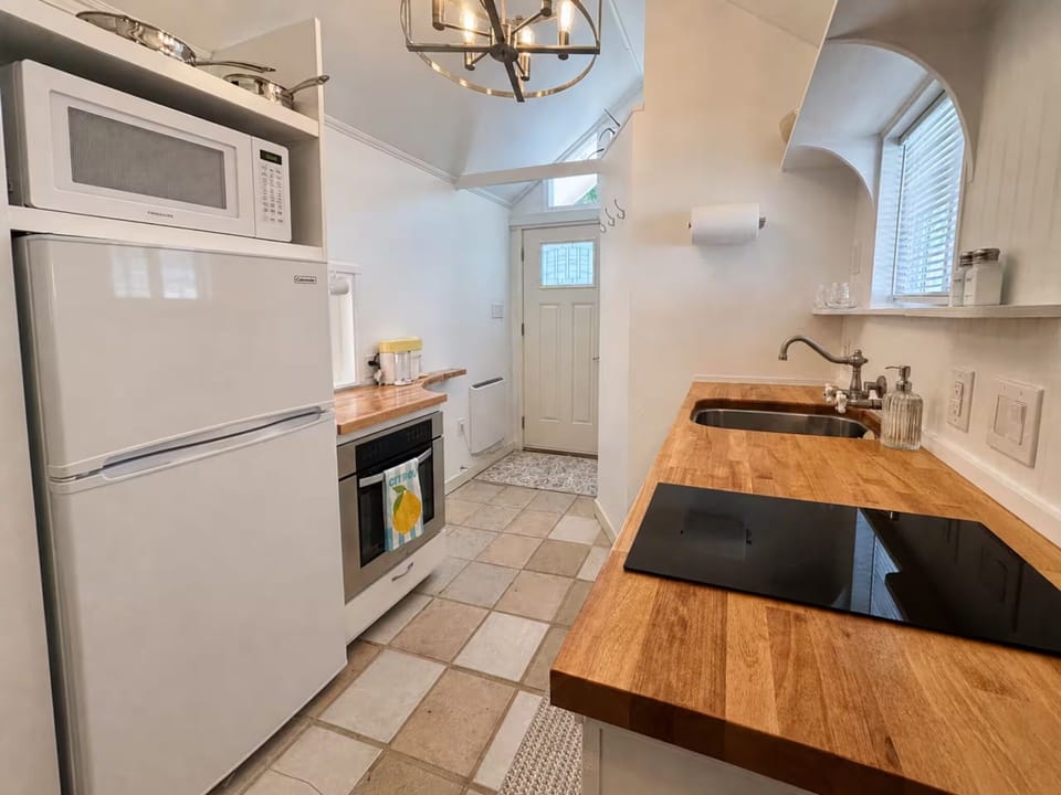 Fully equipped kitchen with cooktop, oven, and butcher block counters