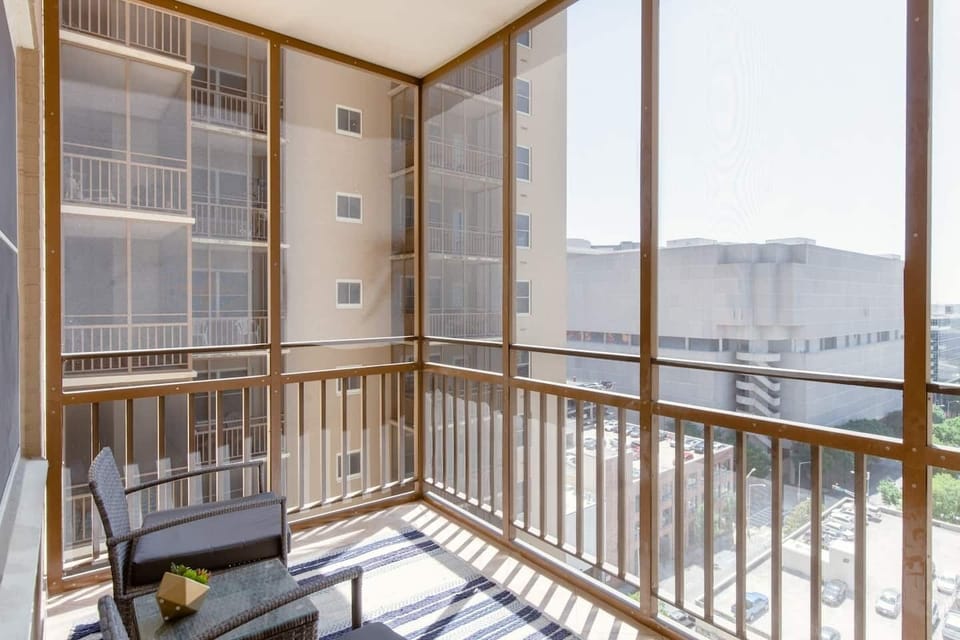 Sunlit screened balcony w/ seating, perfect for relaxing with fresh air