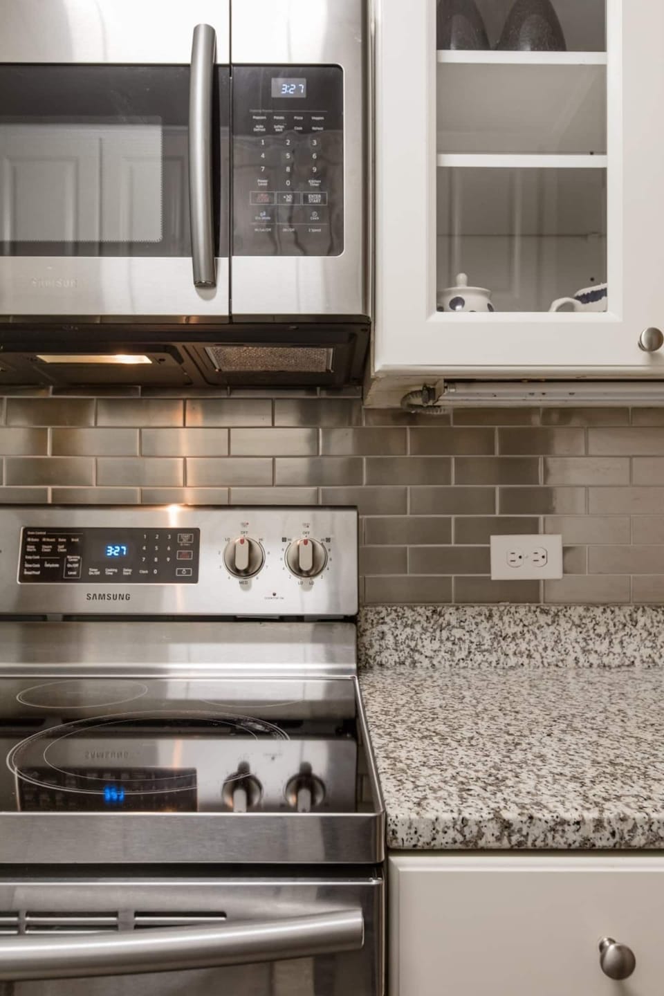 Modern kitchen w/ stainless steel stove, tiled backsplash & granite countertops
