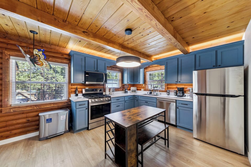 Your fully-equipped kitchen blends rustic warmth with modern conveniences—cook under vaulted wood ceilings and enjoy natural light streaming through large windows.