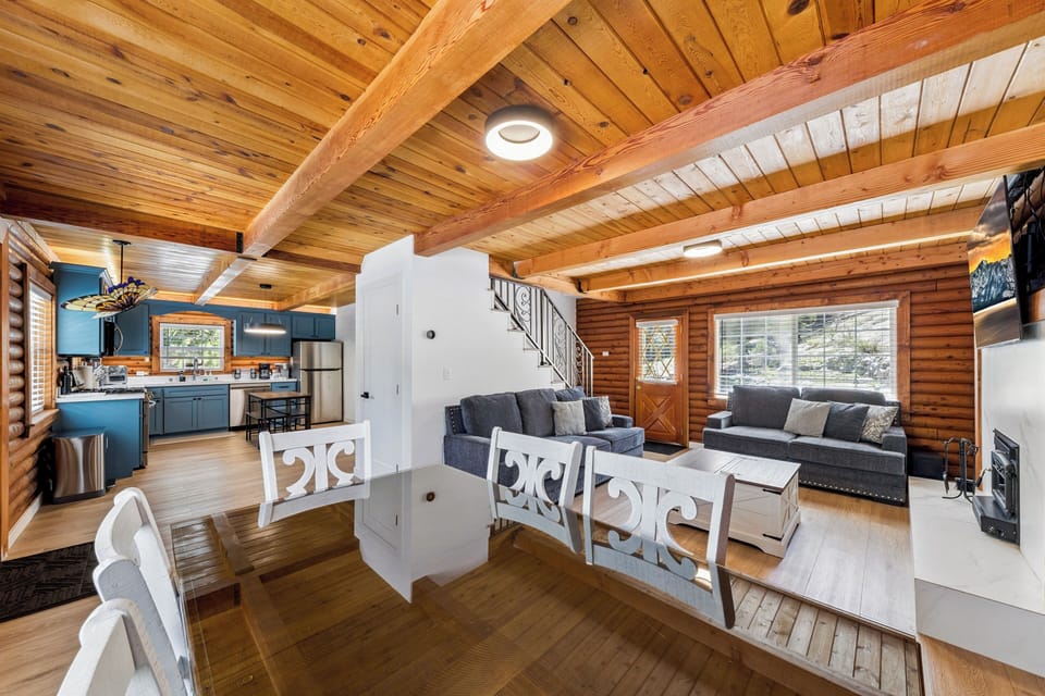 Warm wood tones and exposed beams create your cozy mountain retreat, where the open-concept living space seamlessly connects the kitchen, dining, and living areas for relaxed gatherings.