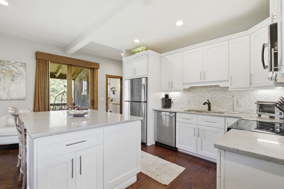 Sleek modern kitchen with white cabinetry and premium stainless appliances.