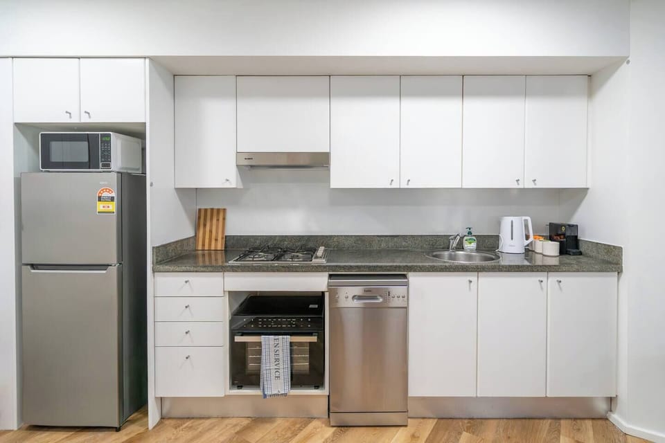 Cook with ease in a well-equipped kitchen featuring a stove, oven, microwave, dishwasher, and Nespresso machine, all set up for simple meals and easy mornings.