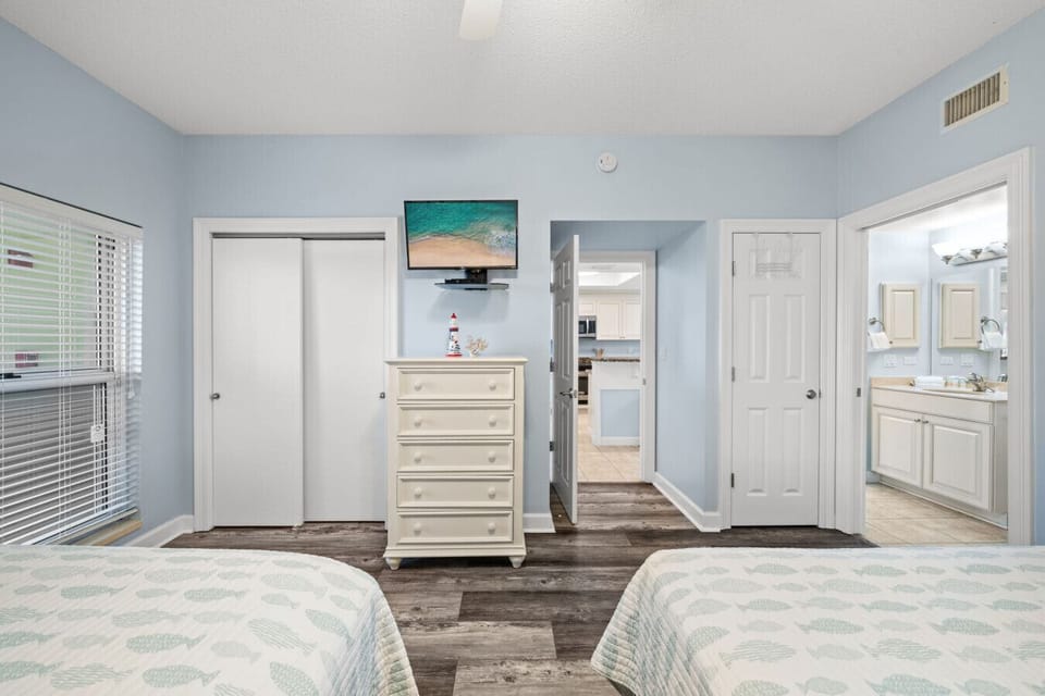 Spacious guest room with two queen-size beds and coastal décor for a relaxing beach stay.