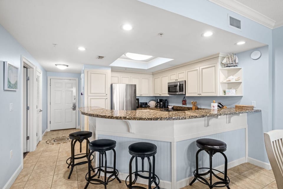 Spacious kitchen with breakfast bar and coastal décor, ideal for group dining and gatherings.