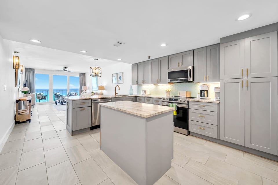Your sleek, modern kitchen awaits with granite countertops, stainless steel appliances, and stunning ocean views through floor-to-ceiling windows.