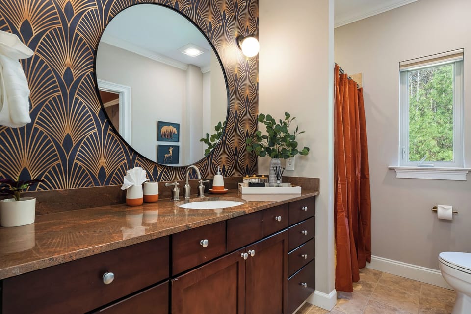 Bathroom with statement mirror and custom vanity - design-forward details throughout the home