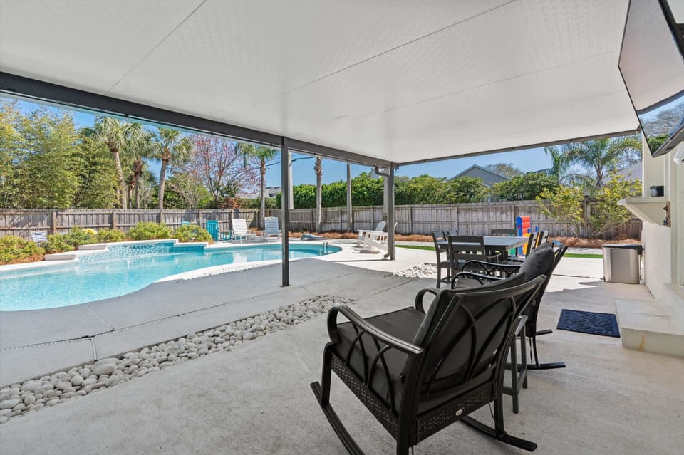 Covered patio with poolside seating and shade