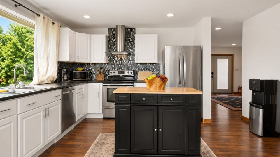 Gas range framed by bright kitchen windows