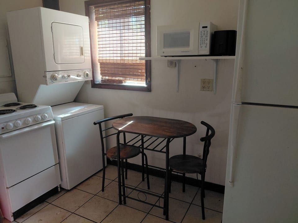 Full size refrigerator and washer/dryer in kitchen.