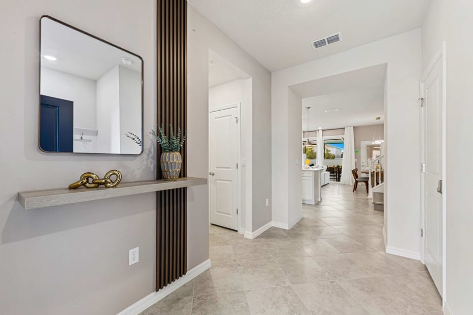 Bright, minimalist foyer with tile floors and modern accents leads to the open-concept kitchen and living area-drop your bags and relax.