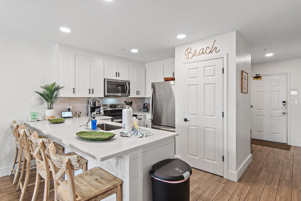 A crisp white kitchen with bar seating and charming seaside touches.